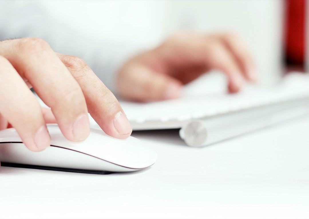 womans hands using mouse and keyboard in office